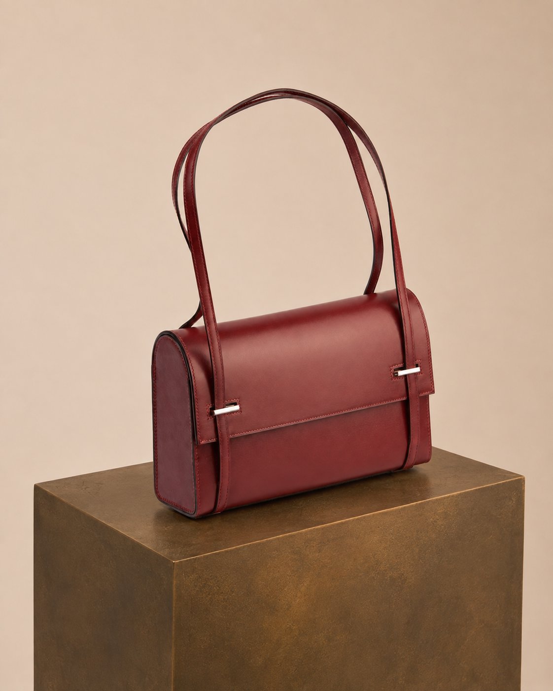 Bolsa HERMES - BOX LEATHER CLUTCH, couro liso bordô, still sobre pedestal bronze